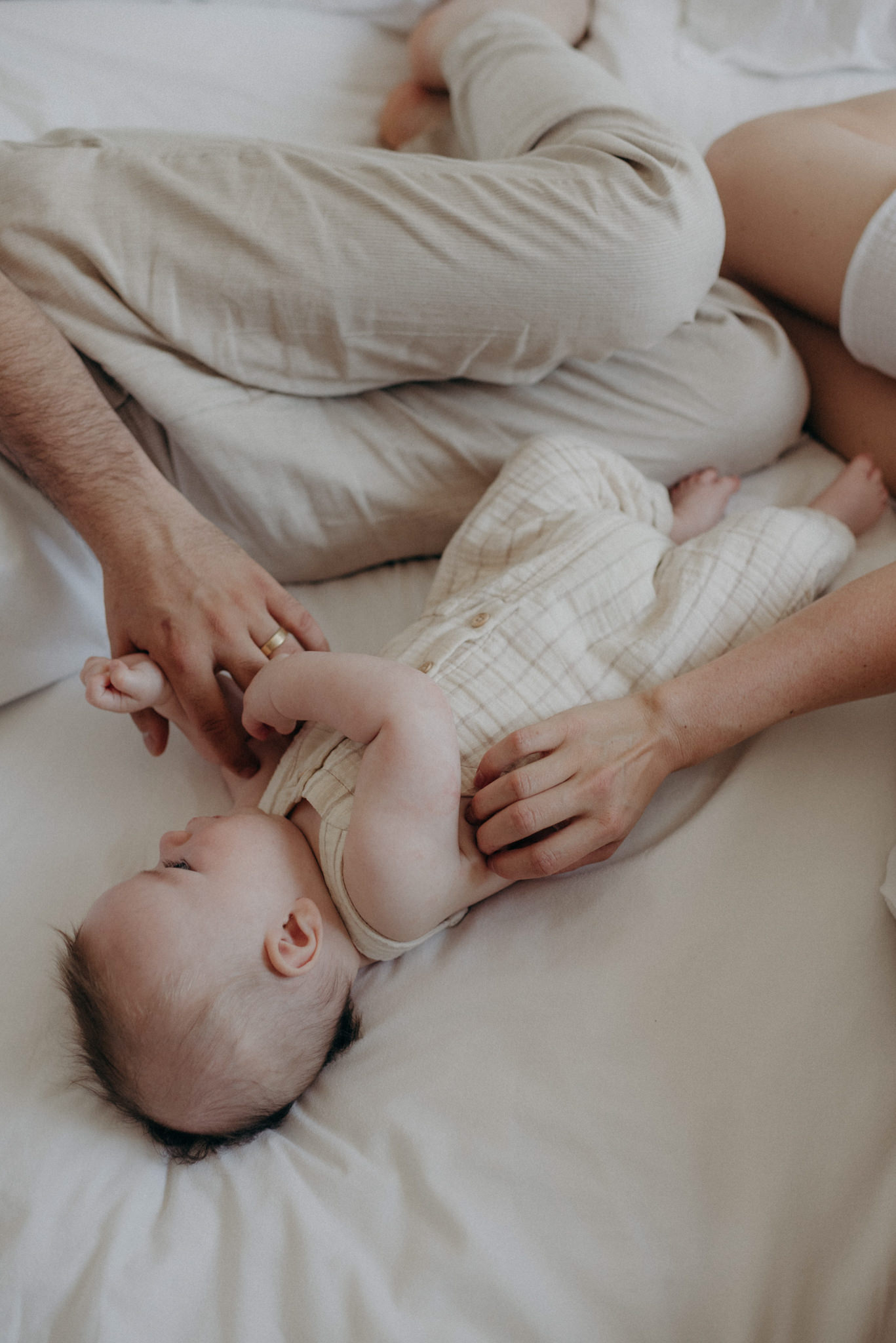 mother and father lying in bed with infant son