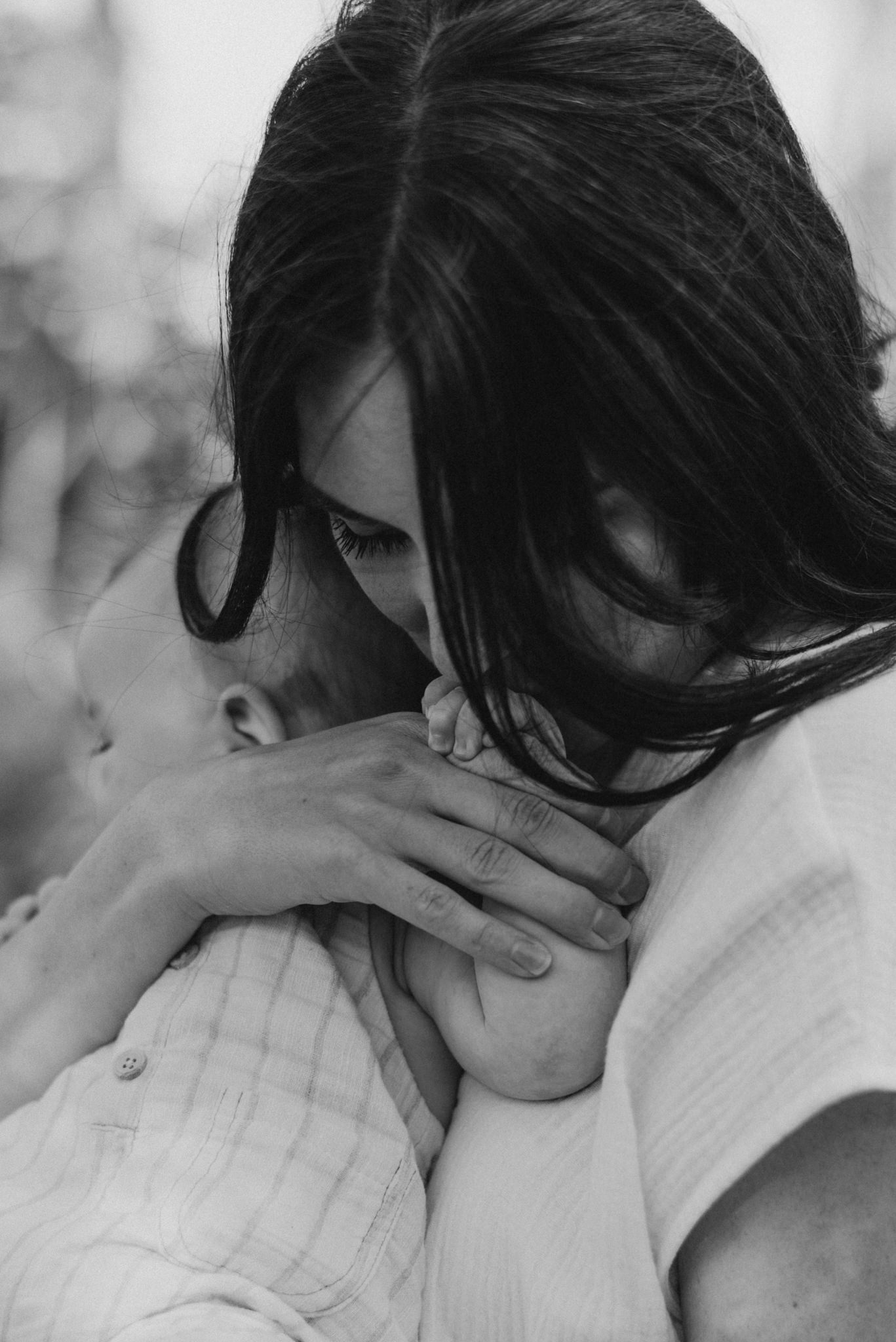 mother kissing baby's fingers