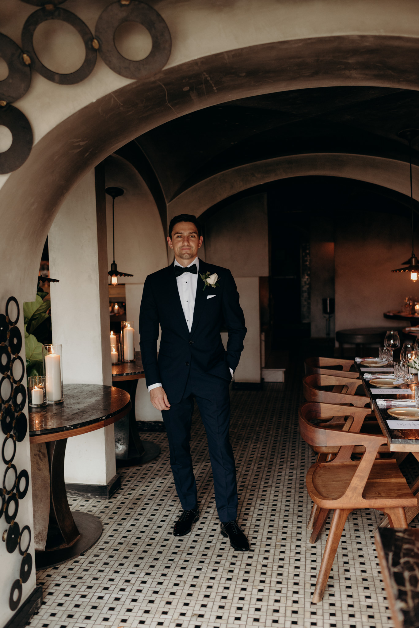 groom standing in arched restaurant