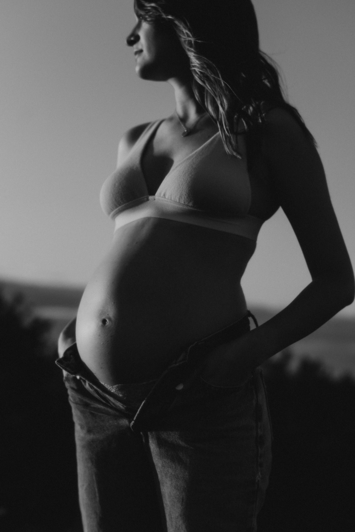 bra and jeans maternity photo in a field